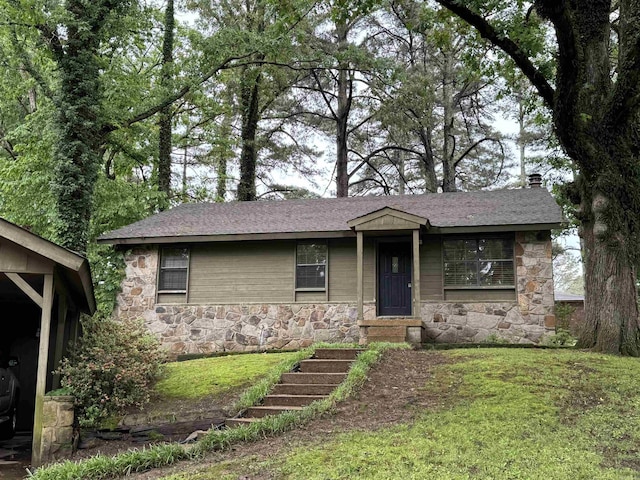 ranch-style home with roof with shingles, a front yard, and stone siding