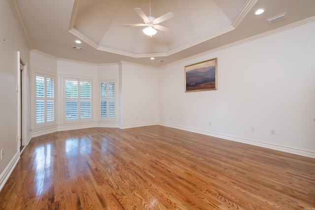 spare room featuring crown molding, a ceiling fan, wood finished floors, and visible vents