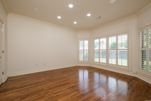 spare room with crown molding, wood finished floors, and visible vents