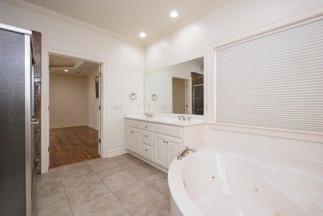 full bathroom featuring a jetted tub, double vanity, a stall shower, a sink, and ornamental molding