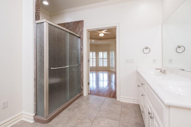 bathroom featuring baseboards, a sink, a stall shower, and ornamental molding