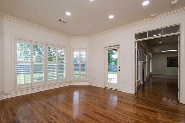 empty room featuring crown molding, recessed lighting, wood finished floors, and visible vents