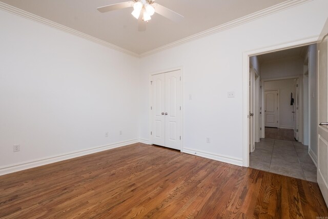 unfurnished bedroom featuring crown molding, a ceiling fan, baseboards, and wood finished floors