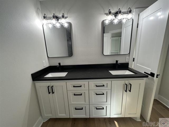 10 Sweetbrush, Texarkana, TX 75503 - bathroom with double vanity, a sink, baseboards, and wood finished floors