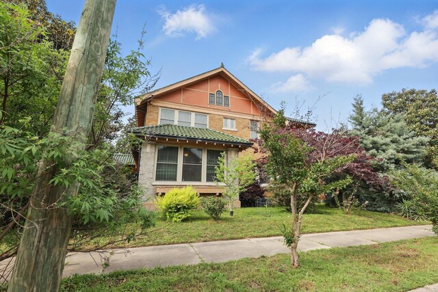 view of front of property featuring brick siding and a front lawn
