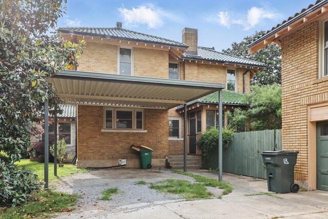 back of property featuring fence, a chimney, entry steps, and brick siding