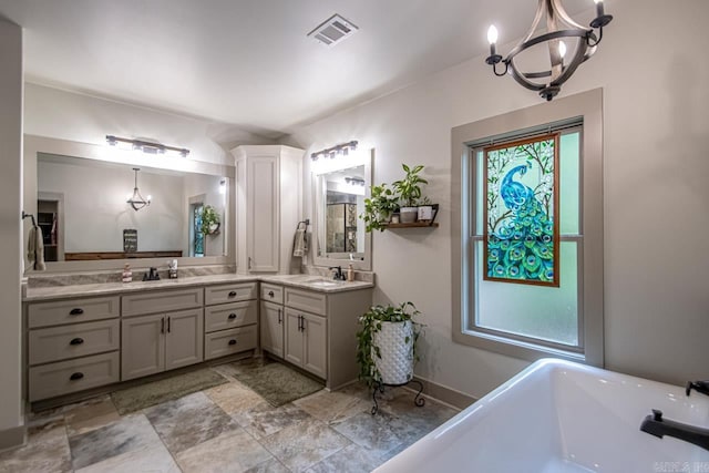 4201 Lovell Ln, Benton, AR 72019 - bathroom featuring a sink, double vanity, a chandelier, visible vents, and a soaking tub