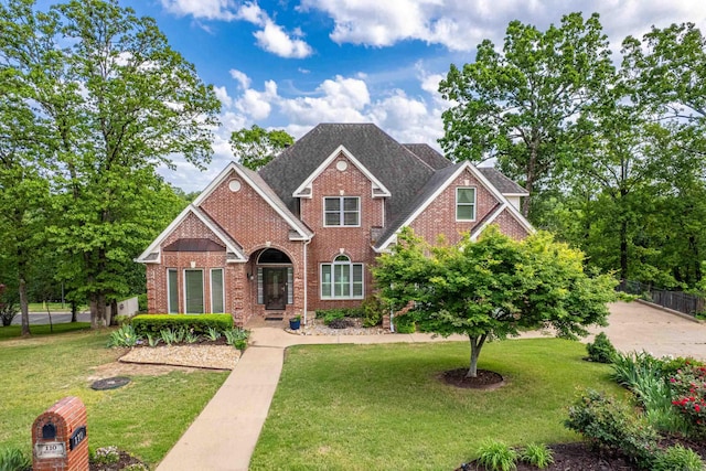 view of front of property featuring fence, a front yard, and brick siding