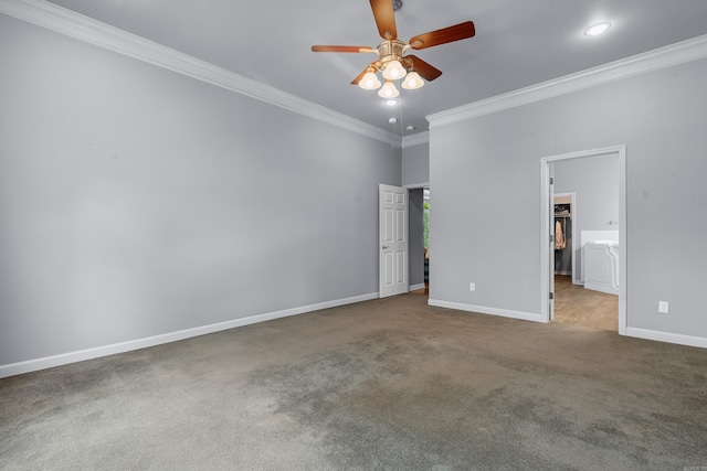 unfurnished bedroom with a walk in closet, crown molding, baseboards, carpet, and recessed lighting