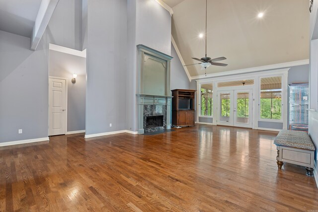 unfurnished living room with baseboards, high vaulted ceiling, ceiling fan, and a high end fireplace