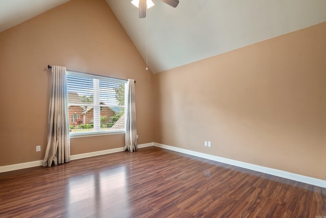spare room with baseboards, ceiling fan, dark wood finished floors, and lofted ceiling