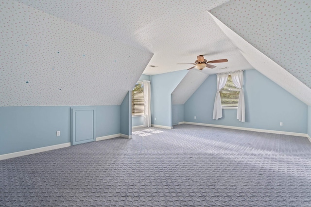 additional living space featuring vaulted ceiling, baseboards, a ceiling fan, and carpet flooring