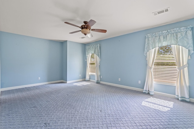 carpeted empty room with ceiling fan, visible vents, and baseboards