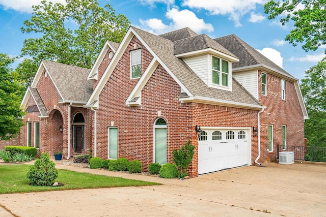 view of front of home with concrete driveway, brick siding, central AC unit, and a shingled roof