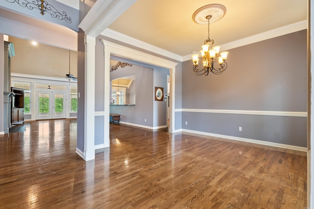 spare room featuring french doors, crown molding, wood finished floors, baseboards, and ceiling fan with notable chandelier