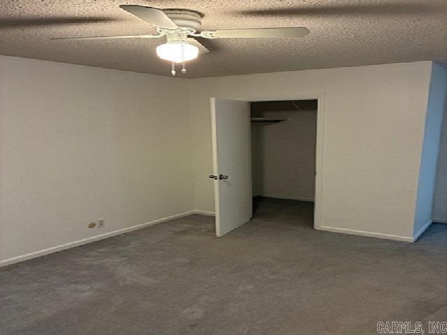 unfurnished bedroom featuring carpet floors, a closet, baseboards, ceiling fan, and a textured ceiling