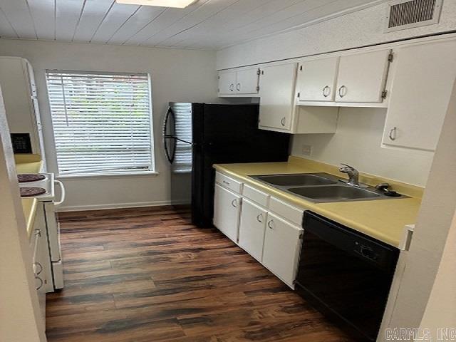 kitchen with dark wood-type flooring, a sink, white cabinetry, and black appliances