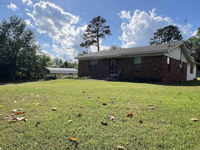 exterior space featuring brick siding, a detached carport, and a lawn