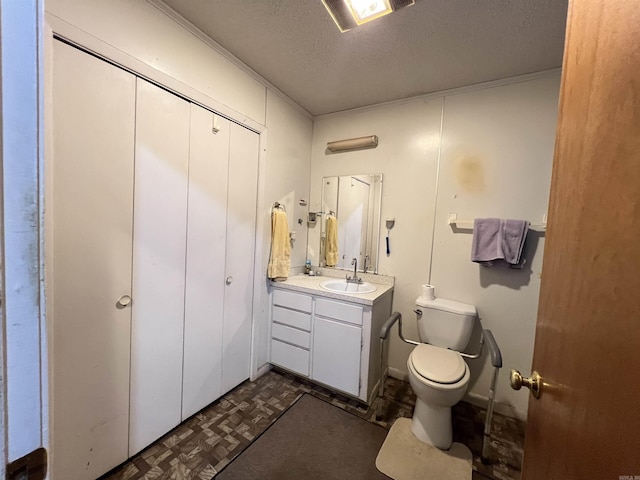 bathroom featuring vanity, a textured ceiling, and toilet