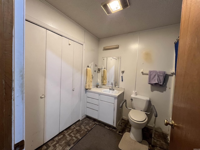 bathroom featuring vanity, toilet, and a textured ceiling