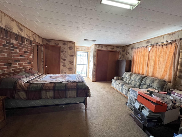 carpeted bedroom featuring wood walls and visible vents