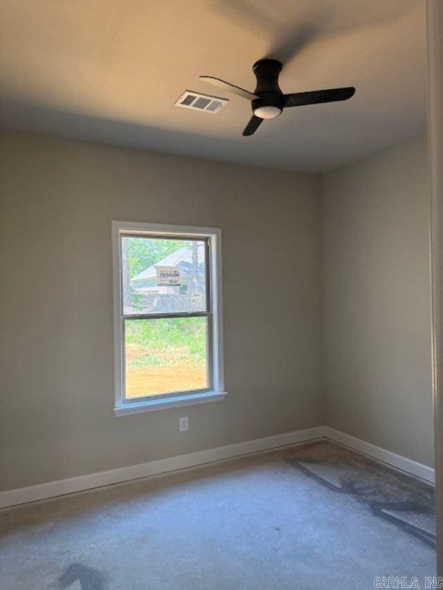 spare room featuring visible vents, a ceiling fan, and baseboards