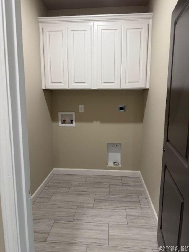 washroom with washer hookup, baseboards, electric dryer hookup, and cabinet space