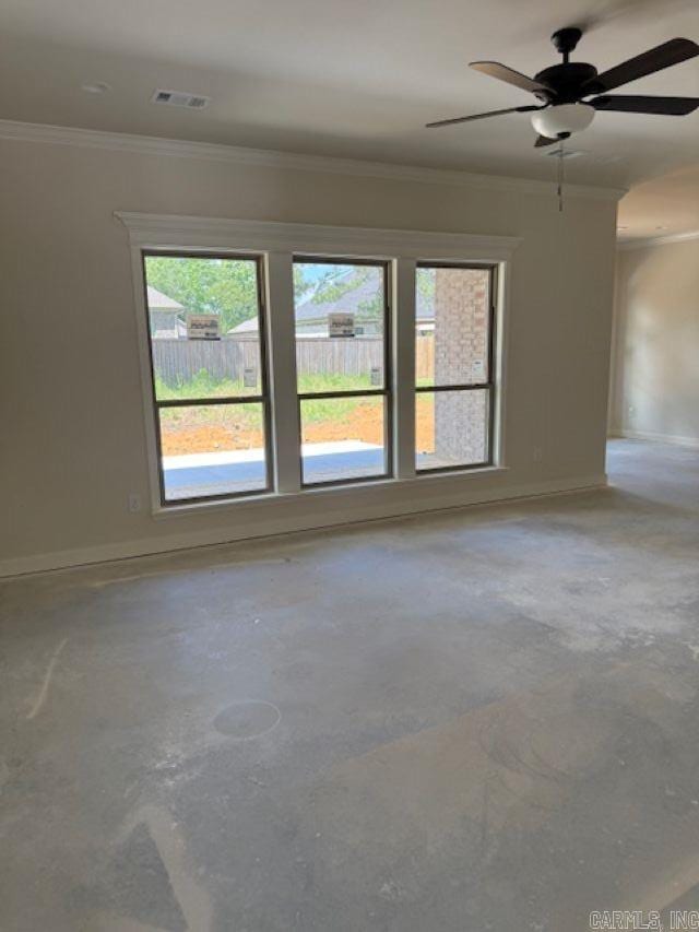 spare room featuring crown molding, ceiling fan, concrete floors, and baseboards