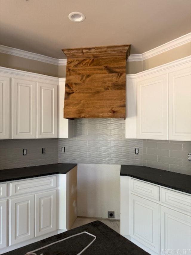 kitchen featuring crown molding, decorative backsplash, white cabinets, and dark countertops
