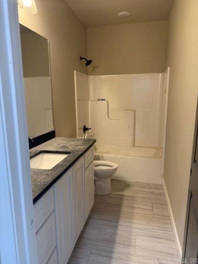 full bath featuring toilet, baseboards, shower / tub combination, and vanity