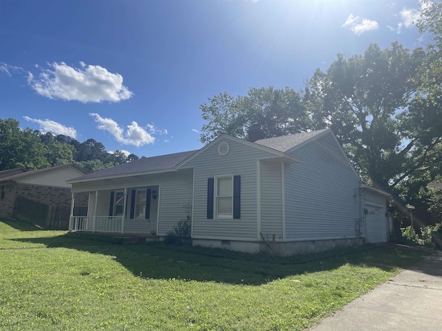view of side of home with a porch, a lawn, an attached garage, and crawl space