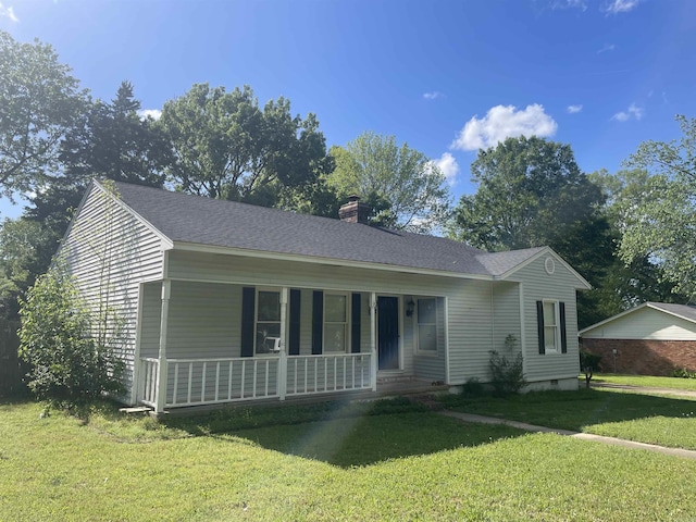 view of front of home featuring a chimney, a porch, and a front lawn