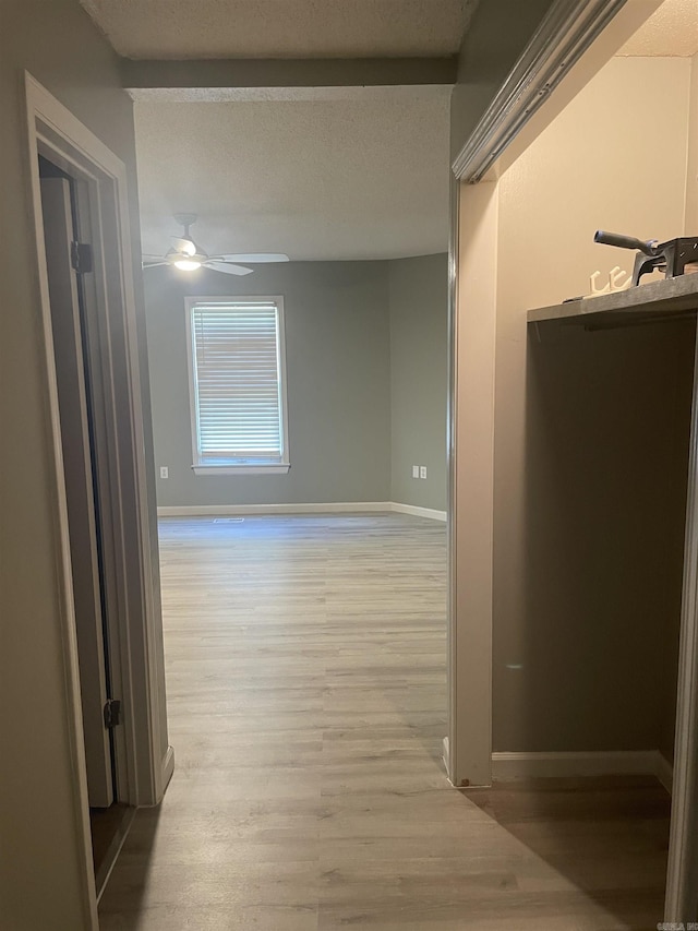hall featuring baseboards and wood finished floors