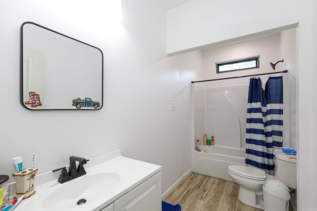 full bath featuring wood finished floors, shower / tub combo, vanity, baseboards, and toilet