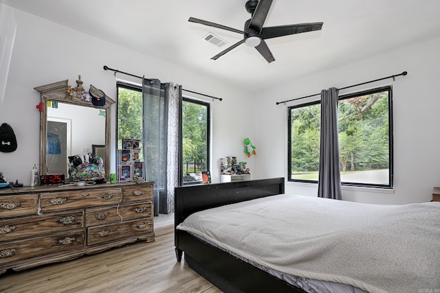 bedroom featuring visible vents, light wood finished floors, and ceiling fan