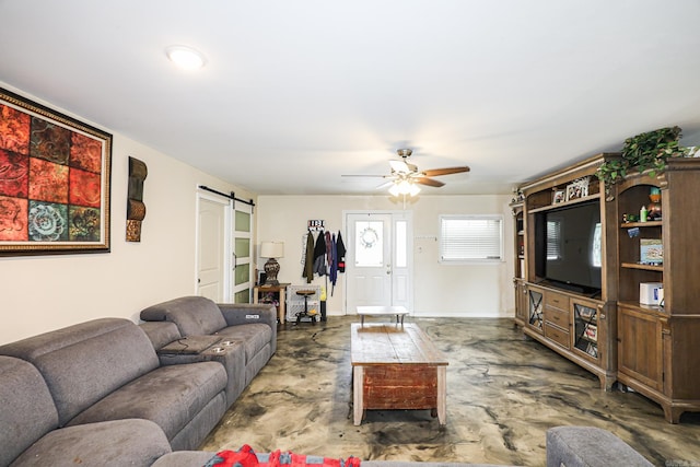 living room featuring a ceiling fan, a barn door, concrete floors, and baseboards