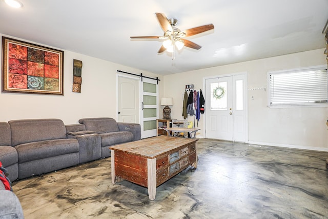living room featuring finished concrete flooring, ceiling fan, and a barn door