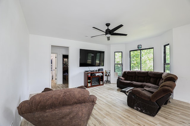 living room featuring plenty of natural light, ceiling fan, and light wood-type flooring