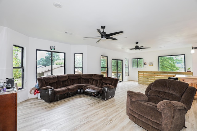 living room with a wealth of natural light, a ceiling fan, light wood-style flooring, and visible vents