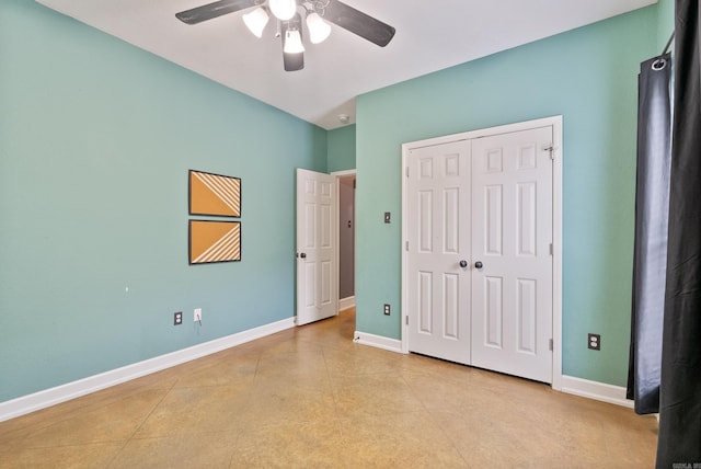 unfurnished bedroom with baseboards, ceiling fan, and a closet
