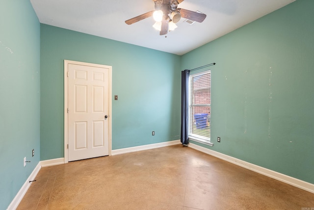 empty room with baseboards, ceiling fan, and concrete floors