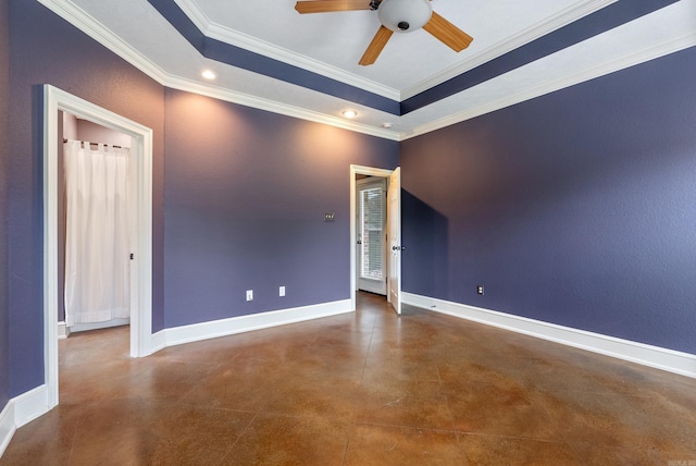 spare room with crown molding, concrete flooring, baseboards, a tray ceiling, and a ceiling fan