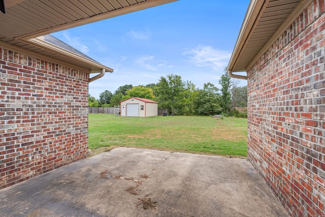 view of patio / terrace with a detached garage and an outbuilding