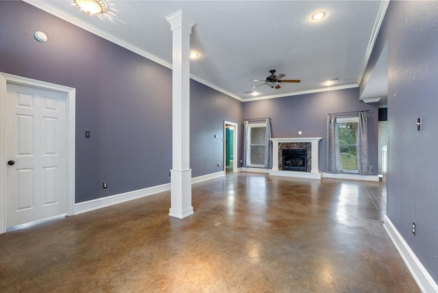 unfurnished living room featuring baseboards, a ceiling fan, decorative columns, and a fireplace with raised hearth