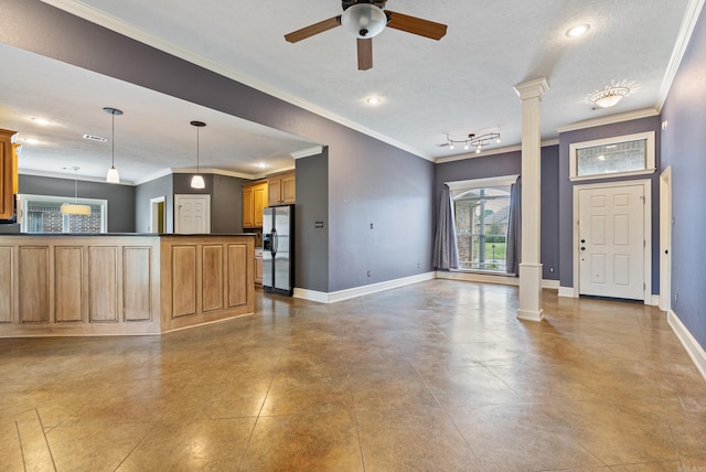 unfurnished living room with crown molding, ceiling fan, decorative columns, and baseboards