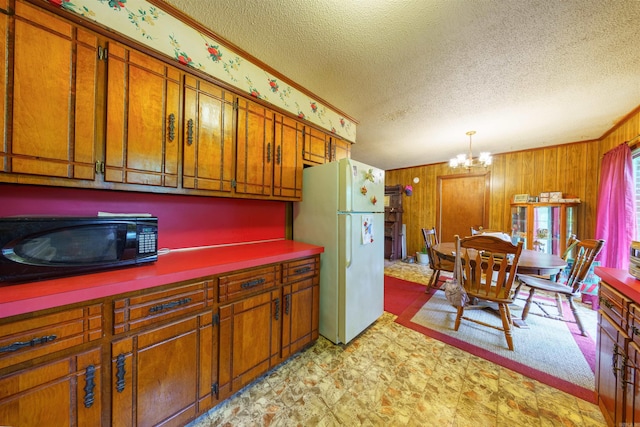 3009 N Main St, Mount Pleasant, AR 72651 - kitchen featuring freestanding refrigerator, a textured ceiling, brown cabinets, and a notable chandelier