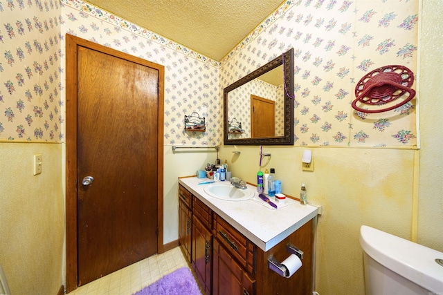3009 N Main St, Mount Pleasant, AR 72651 - bathroom featuring vanity, toilet, wallpapered walls, a textured ceiling, and tile patterned floors