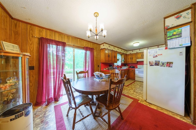 3009 N Main St, Mount Pleasant, AR 72651 - dining space featuring ornamental molding, wood walls, a textured ceiling, and a chandelier