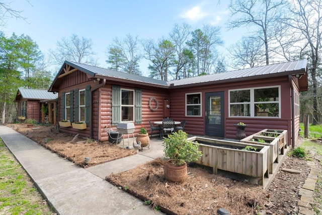 back of property with a patio, metal roof, and log veneer siding