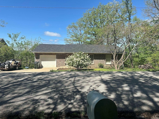 view of front facade featuring a garage, aphalt driveway, and brick siding